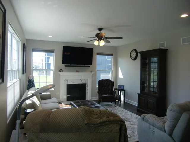 a living room with furniture a fireplace and a flat screen tv