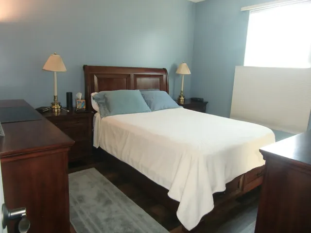 a bedroom with a bed and a lamp on table