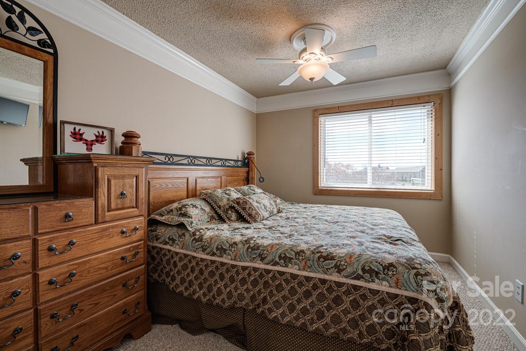 301 Pinnacle Inn Road, Unit 1315 Beech Mountain, NC 28604 - Photo 23 of 47 a bedroom with a bed and a chandelier
