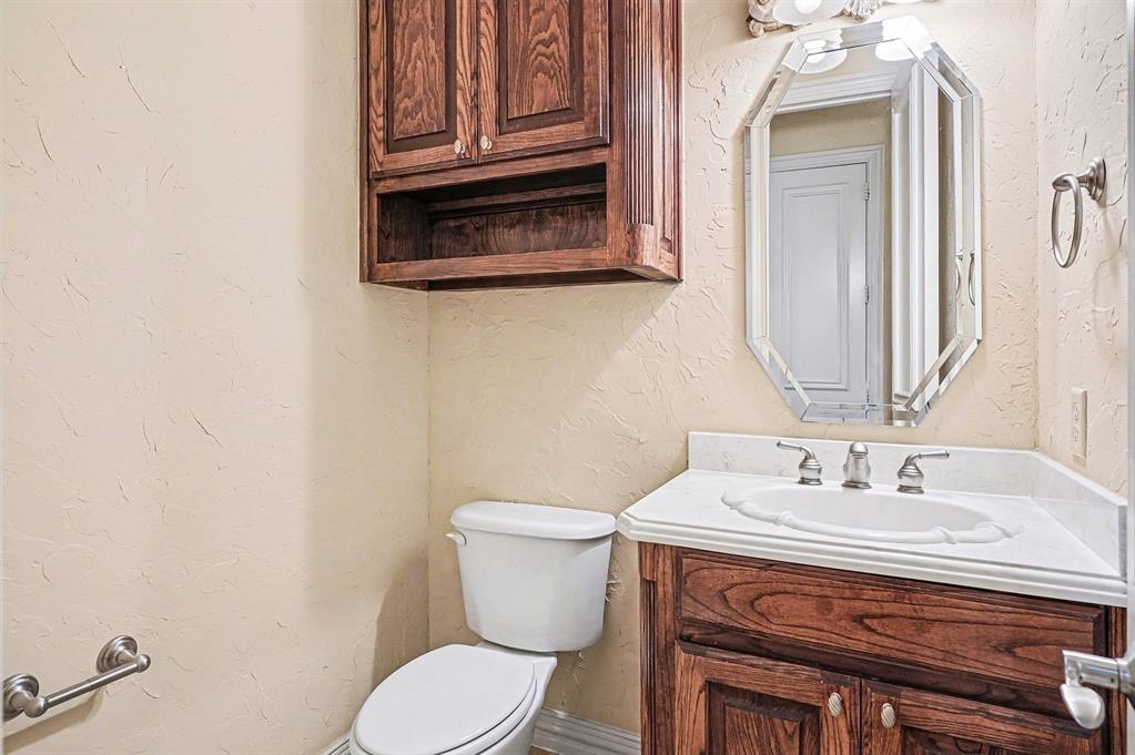 5508 Junius Street Dallas, TX 75214 - Photo 18 of 34 a bathroom with a sink a toilet and mirror