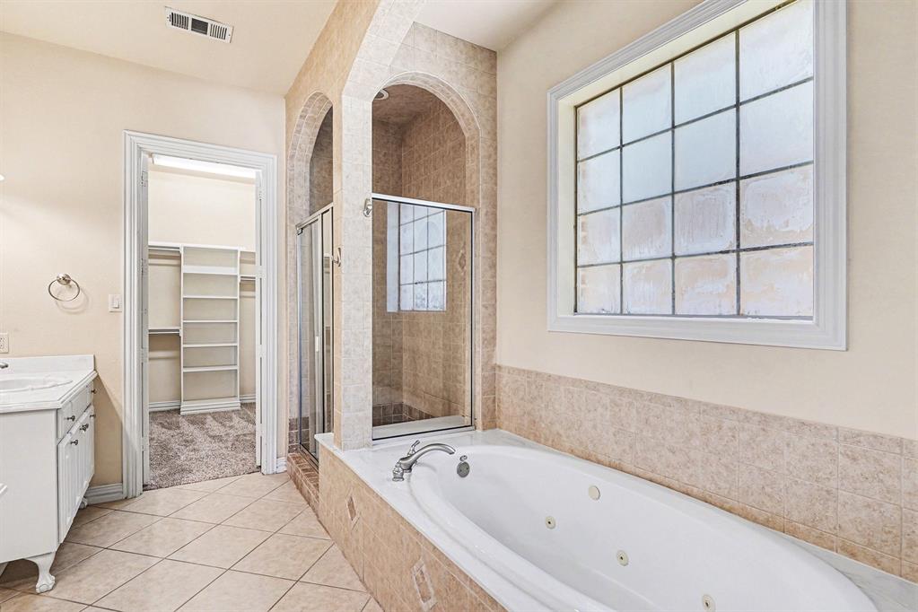 5508 Junius Street Dallas, TX 75214 - Photo 25 of 34 a bathroom with a bathtub and a shower