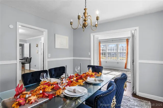 a view of a dining room with furniture a chandelier and wooden floor