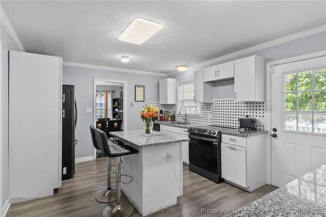 a kitchen with granite countertop a sink appliances cabinets and furniture