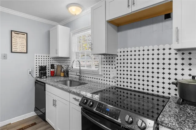 a kitchen with granite countertop a stove and a sink