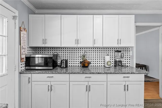 a kitchen with white cabinets and stainless steel appliances