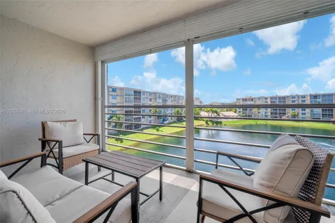 a view of a chairs and table in patio with a lake view