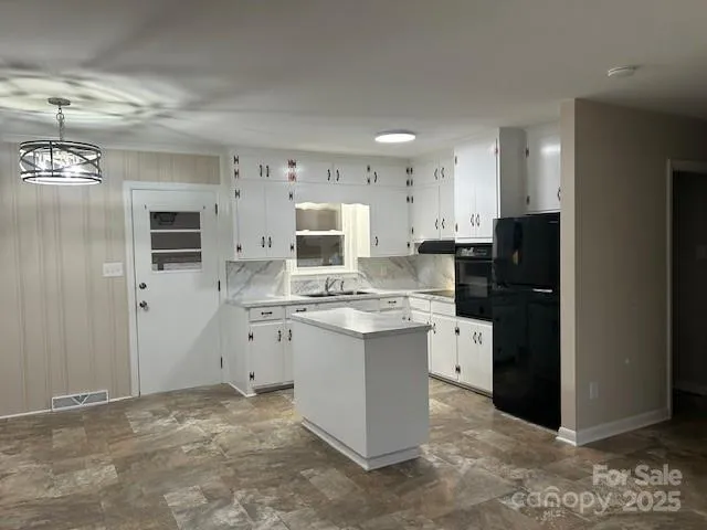 a kitchen with granite countertop white cabinets and refrigerator