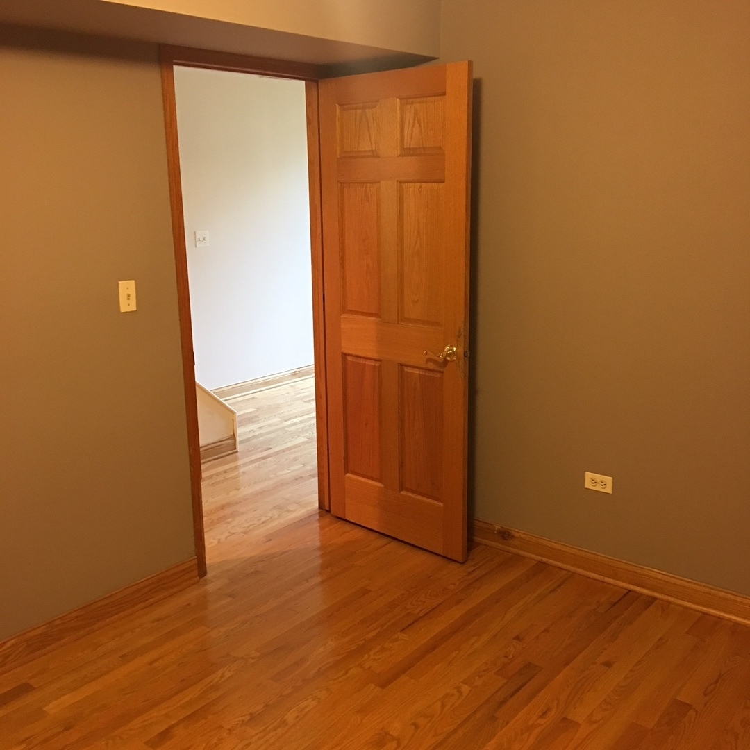 1915 West Huron Street, Unit 2 Chicago, IL 60622 - Photo 7 of 23 an empty room with wooden floor and entrance