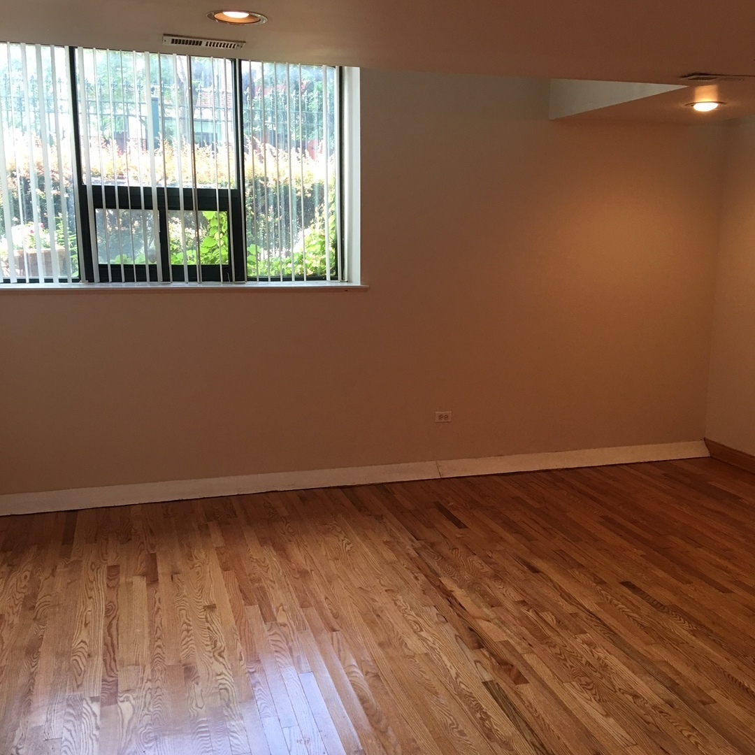 1915 West Huron Street, Unit 2 Chicago, IL 60622 - Photo 8 of 23 an empty room with wooden floor and windows