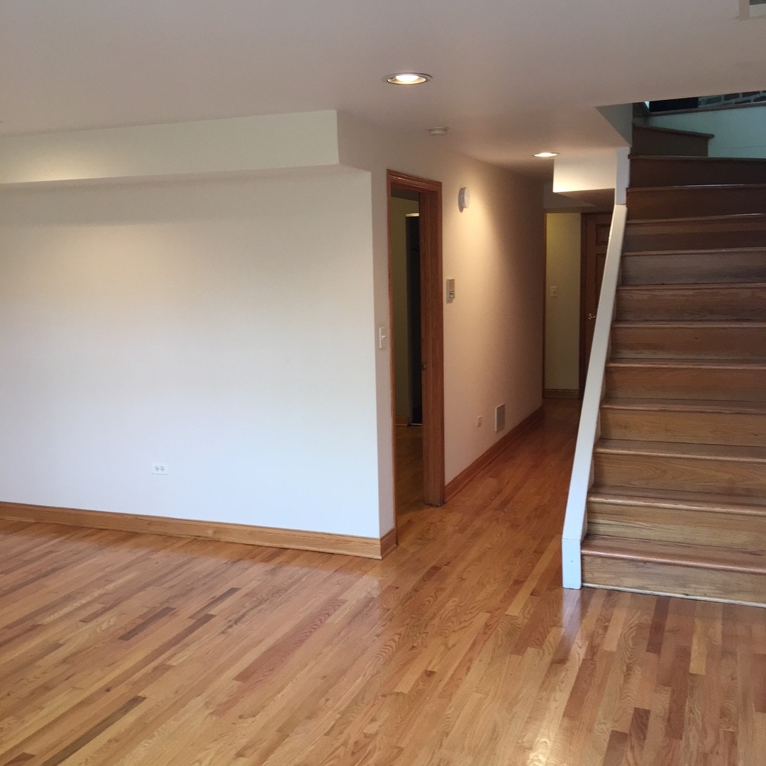1915 West Huron Street, Unit 2 Chicago, IL 60622 - Photo 9 of 23 wooden floor in an empty room with stairs