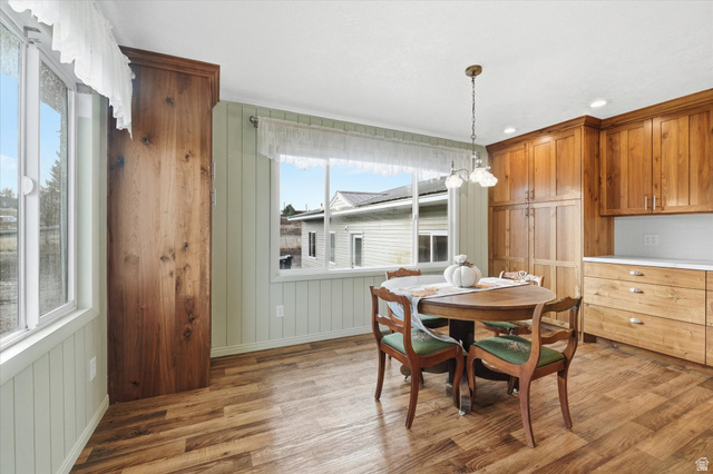 165 Main Street Georgetown, ID 83239 - Photo 9 of 50 Dining space featuring light wood-style floors, wood walls, and a chandelier