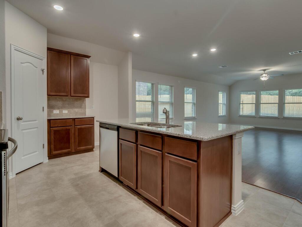 1104 Ridge Runner Drive Georgetown, TX 78628 - Photo 2 of 27 a kitchen with kitchen island granite countertop a stove and a sink