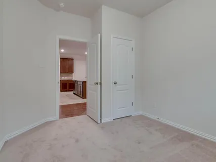 an empty room and a bathroom with a window