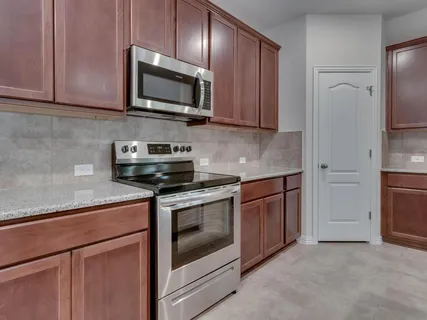 a kitchen with stainless steel appliances granite countertop a stove microwave and refrigerator