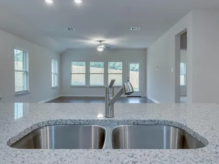 a kitchen with a sink granite counter tops and a window