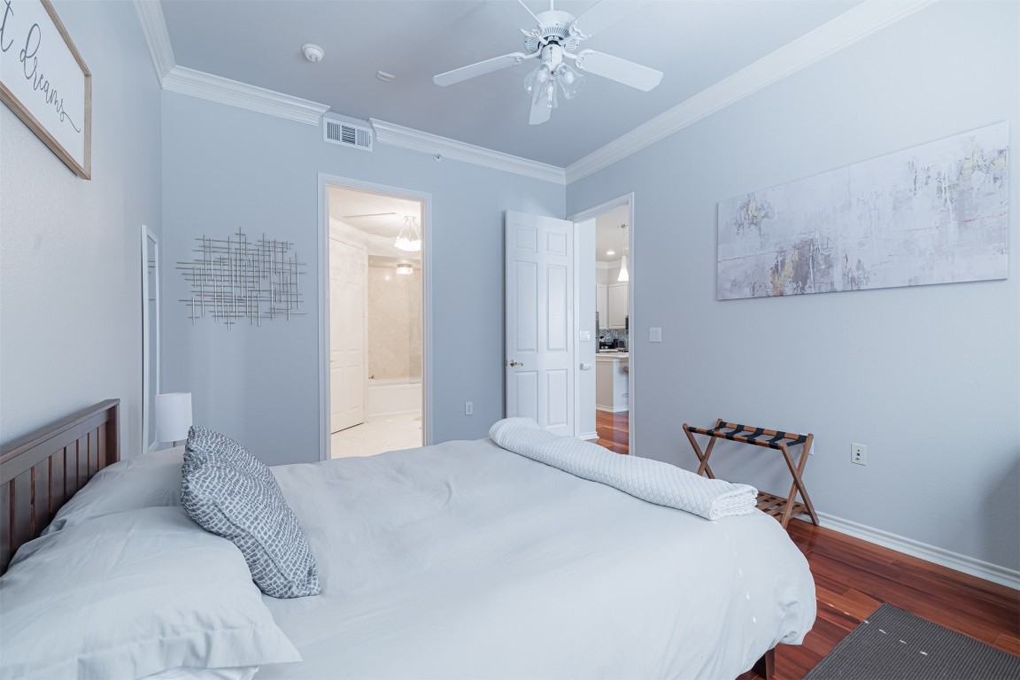 2400 McCue Road, Unit 112 Houston, TX 77056 - Photo 8 of 24 a bedroom with a large bed and a chandelier