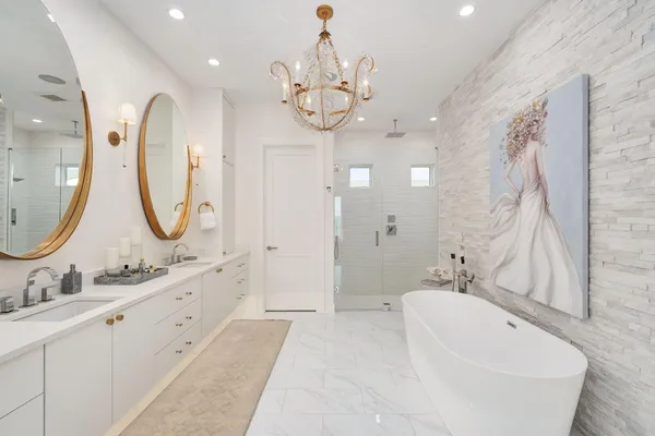 a bathroom with a double vanity sink mirror and bathtub