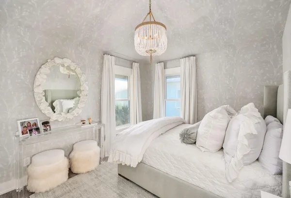 a bedroom with a large bed and a chandelier