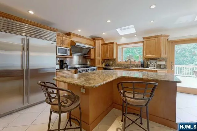 a kitchen with stainless steel appliances granite countertop a stove a sink and a refrigerator