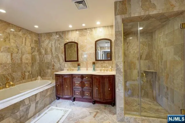 a spacious bathroom with a tub sink shower and mirror