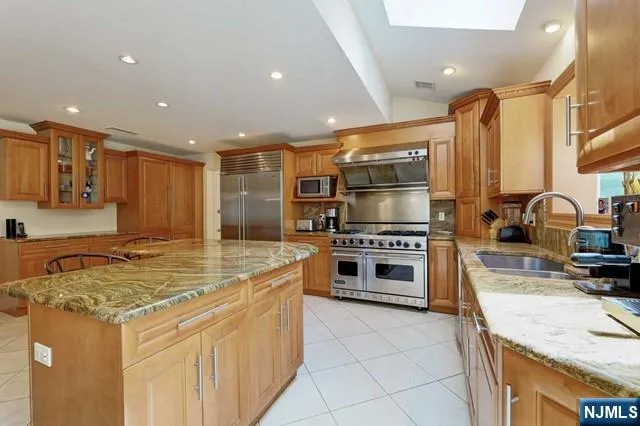 a kitchen with stainless steel appliances granite countertop a stove a sink and a refrigerator