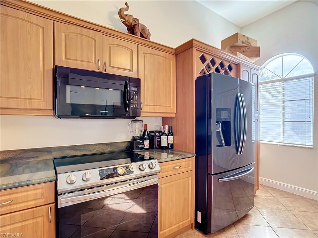 2860 Citrus Lake Drive, Unit R202 Naples, FL 34109 - Photo 11 of 50 a kitchen with stainless steel appliances granite countertop a refrigerator stove and microwave