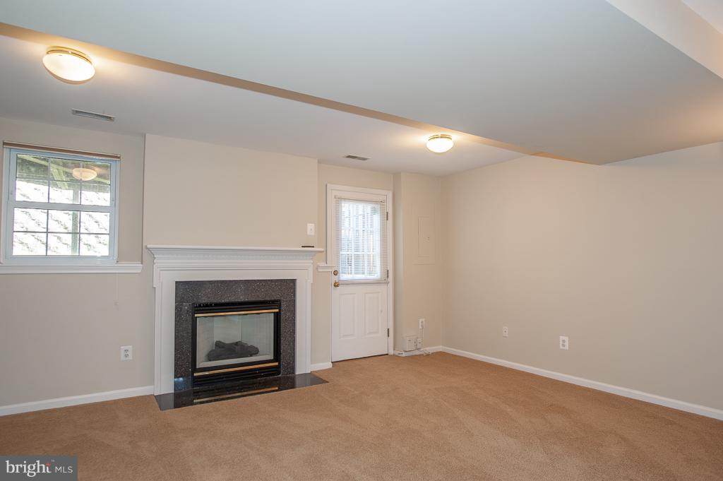6342 Racetec Place Springfield, VA 22150 - Photo 22 of 27 an empty room with a fireplace and window