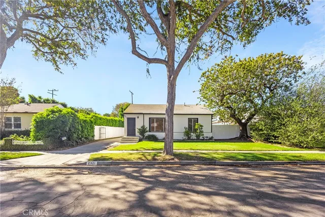 a view of a house with a big yard and large trees