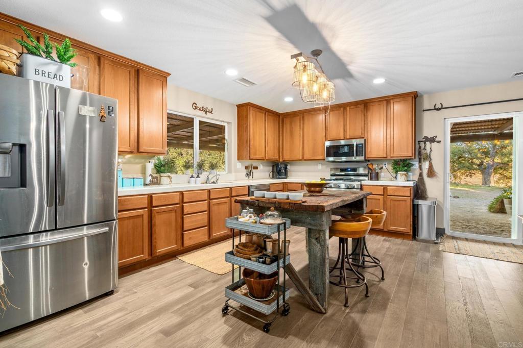 25258 Black Canyon Road Santa Ysabel, CA 92070 - Photo 22 of 69 a kitchen with a table chairs refrigerator and cabinets