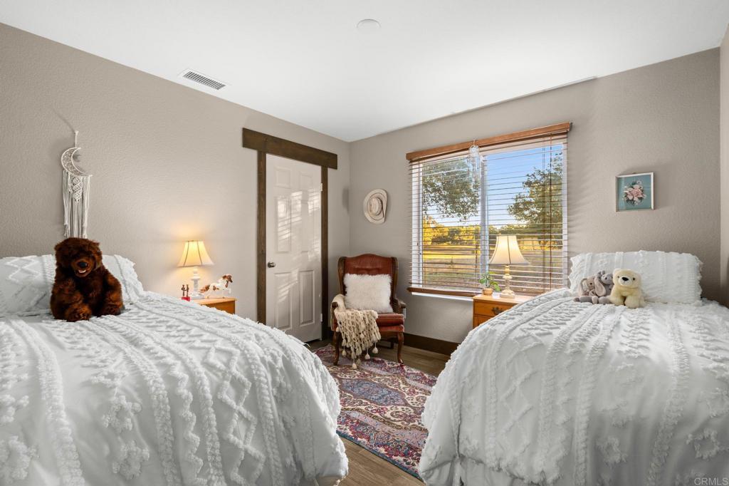 25258 Black Canyon Road Santa Ysabel, CA 92070 - Photo 30 of 69 a bedroom with two bed and a large window