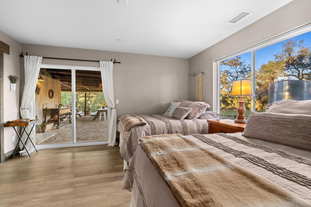 25258 Black Canyon Road Santa Ysabel, CA 92070 - Photo 31 of 71 a bedroom with furniture and wooden floor