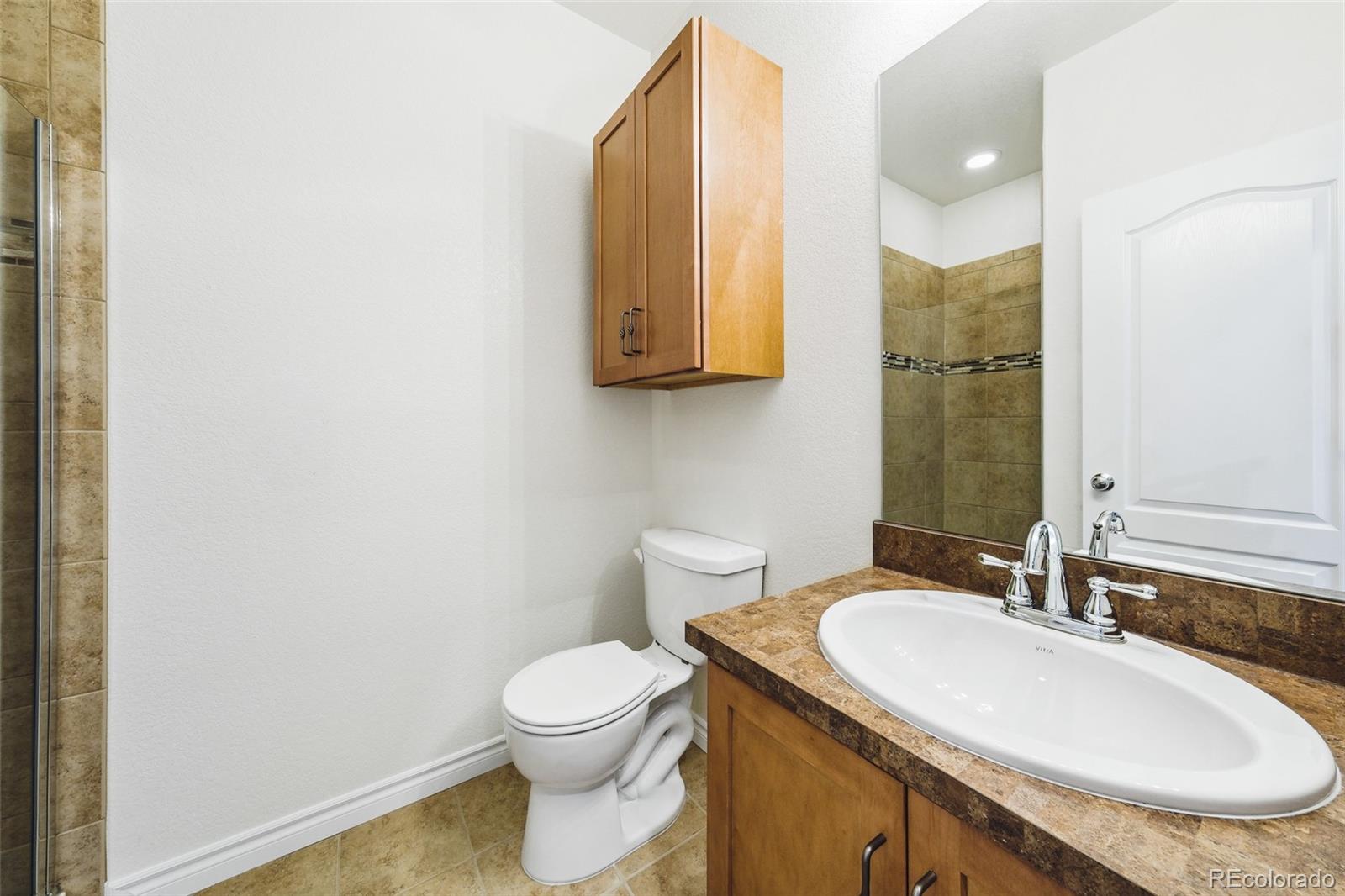 9550 Rosato Court Highlands Ranch, CO 80126 - Photo 14 of 27 a bathroom with a granite countertop sink toilet and a mirror