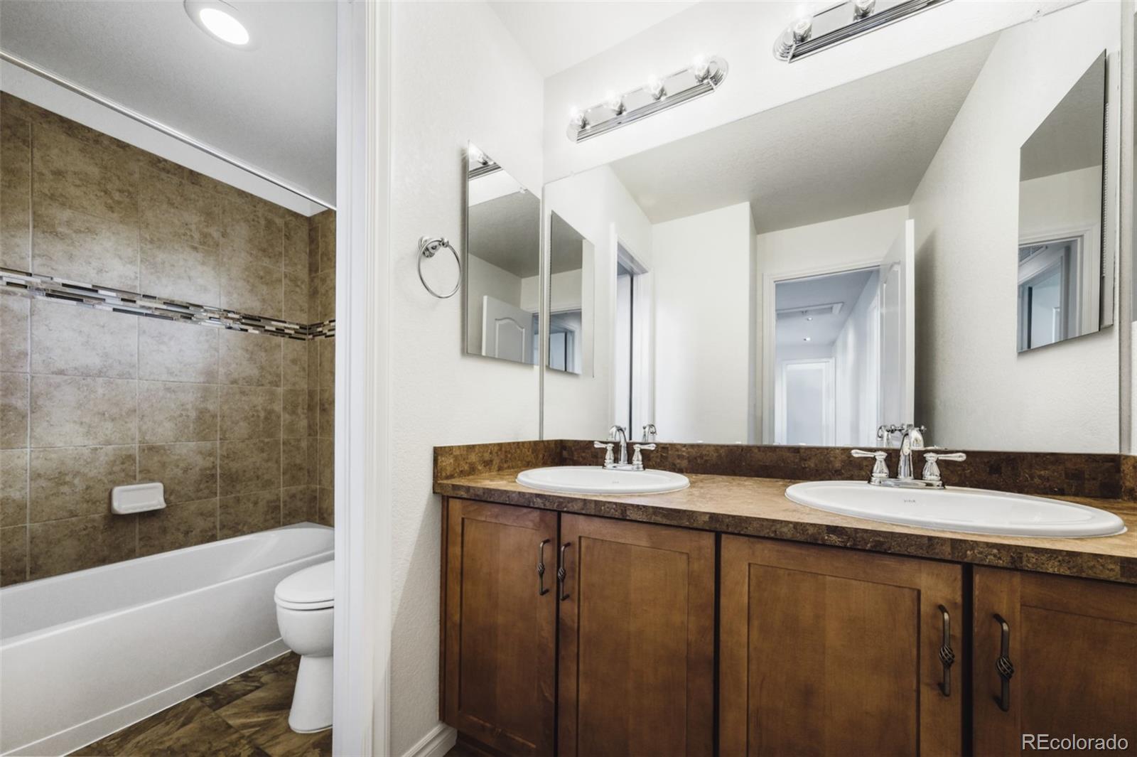 9550 Rosato Court Highlands Ranch, CO 80126 - Photo 21 of 27 a bathroom with a granite countertop sink mirror toilet and bathtub