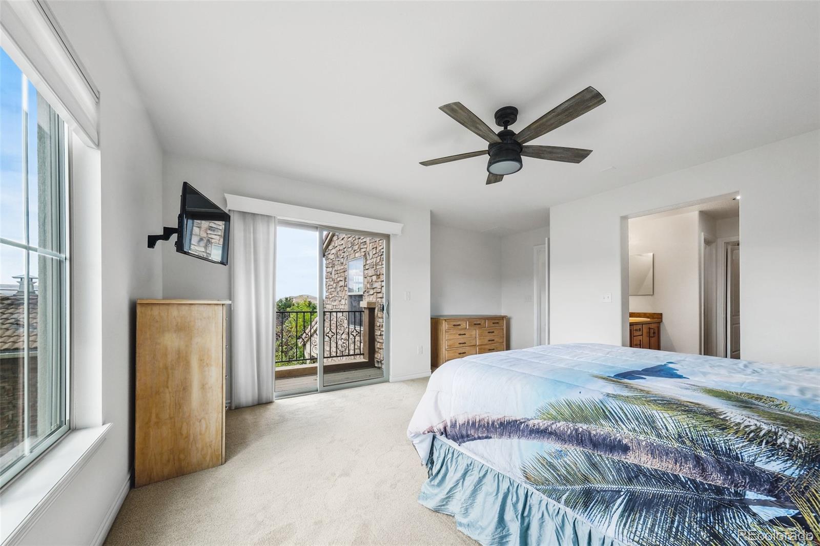 9550 Rosato Court Highlands Ranch, CO 80126 - Photo 22 of 27 a bedroom with a large bed and a chandelier