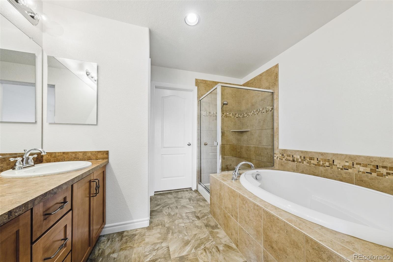 9550 Rosato Court Highlands Ranch, CO 80126 - Photo 24 of 27 a spacious bathroom with a tub sink and mirror