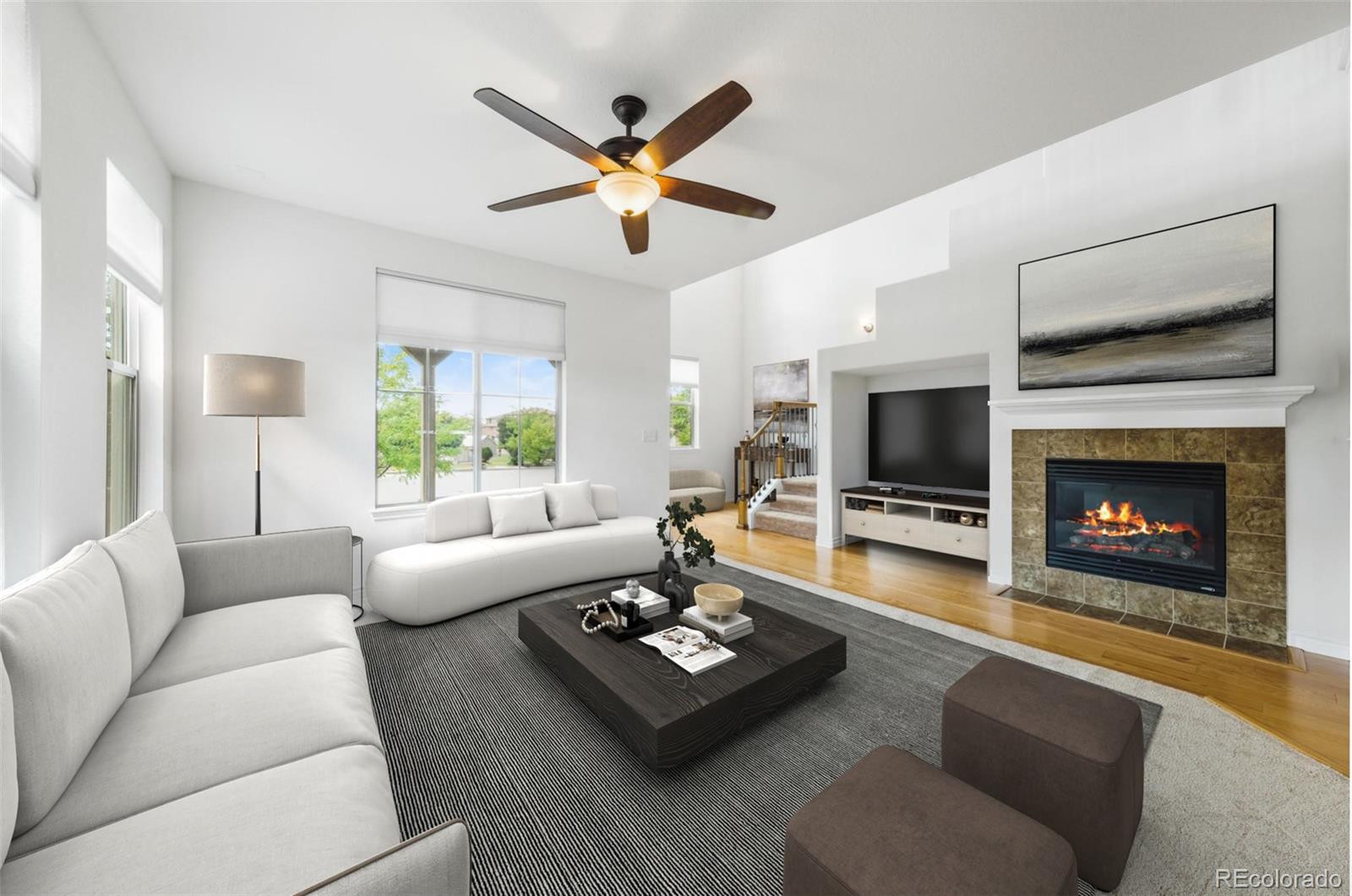 9550 Rosato Court Highlands Ranch, CO 80126 - Photo 6 of 27 a living room with furniture a fireplace a flat screen tv and a large window