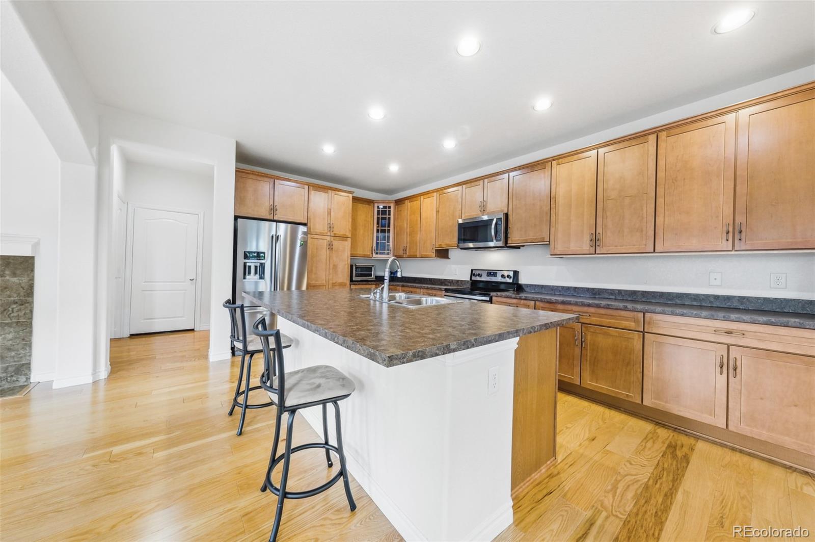 9550 Rosato Court Highlands Ranch, CO 80126 - Photo 10 of 27 a kitchen with stainless steel appliances granite countertop a refrigerator sink and cabinets