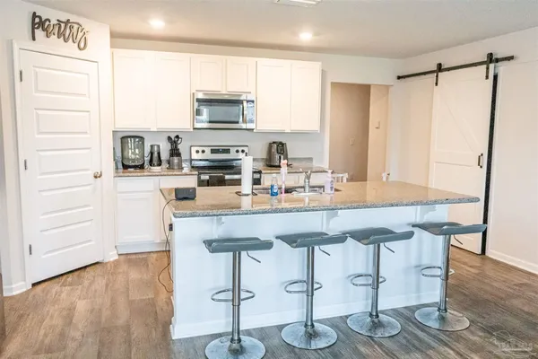 a kitchen with granite countertop a sink appliances and cabinets