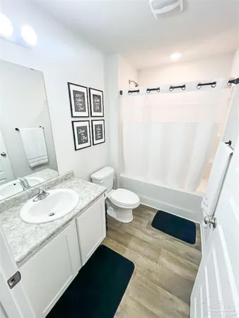 a bathroom with a granite countertop sink a toilet and a mirror