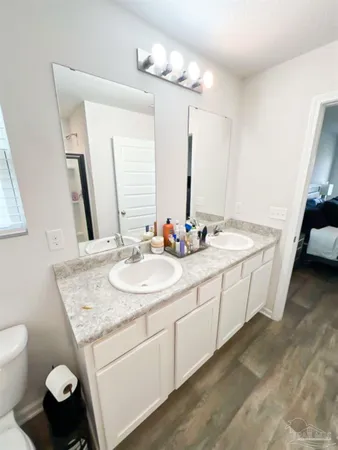 a bathroom with a sink and mirror with bathtub