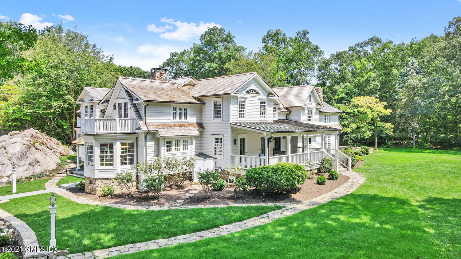 175 Cat Rock Road Cos Cob, CT 06807 - Photo 61 of 72 a front view of a house with a yard table and chairs