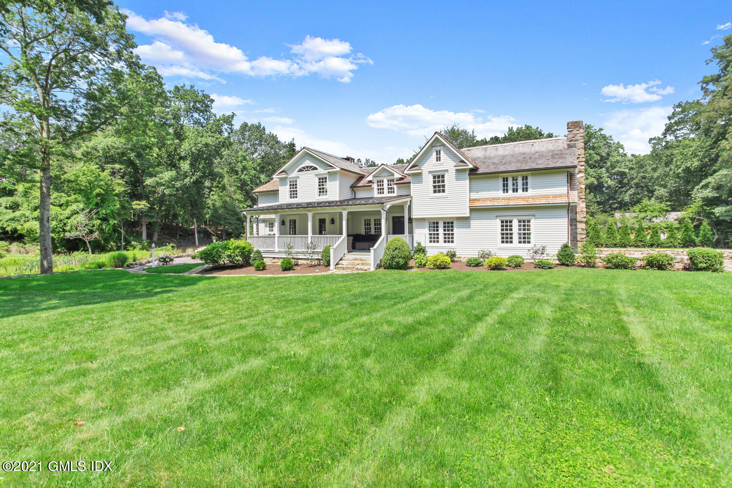 175 Cat Rock Road Cos Cob, CT 06807 - Photo 63 of 72 a front view of a house with a yard table and chairs