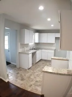 a kitchen with granite countertop sink and cabinets