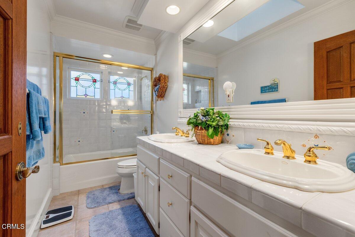 2300 Peninsula Road Oxnard, CA 93035 - Photo 29 of 54 a bathroom with a granite countertop sink a toilet a mirror and shower