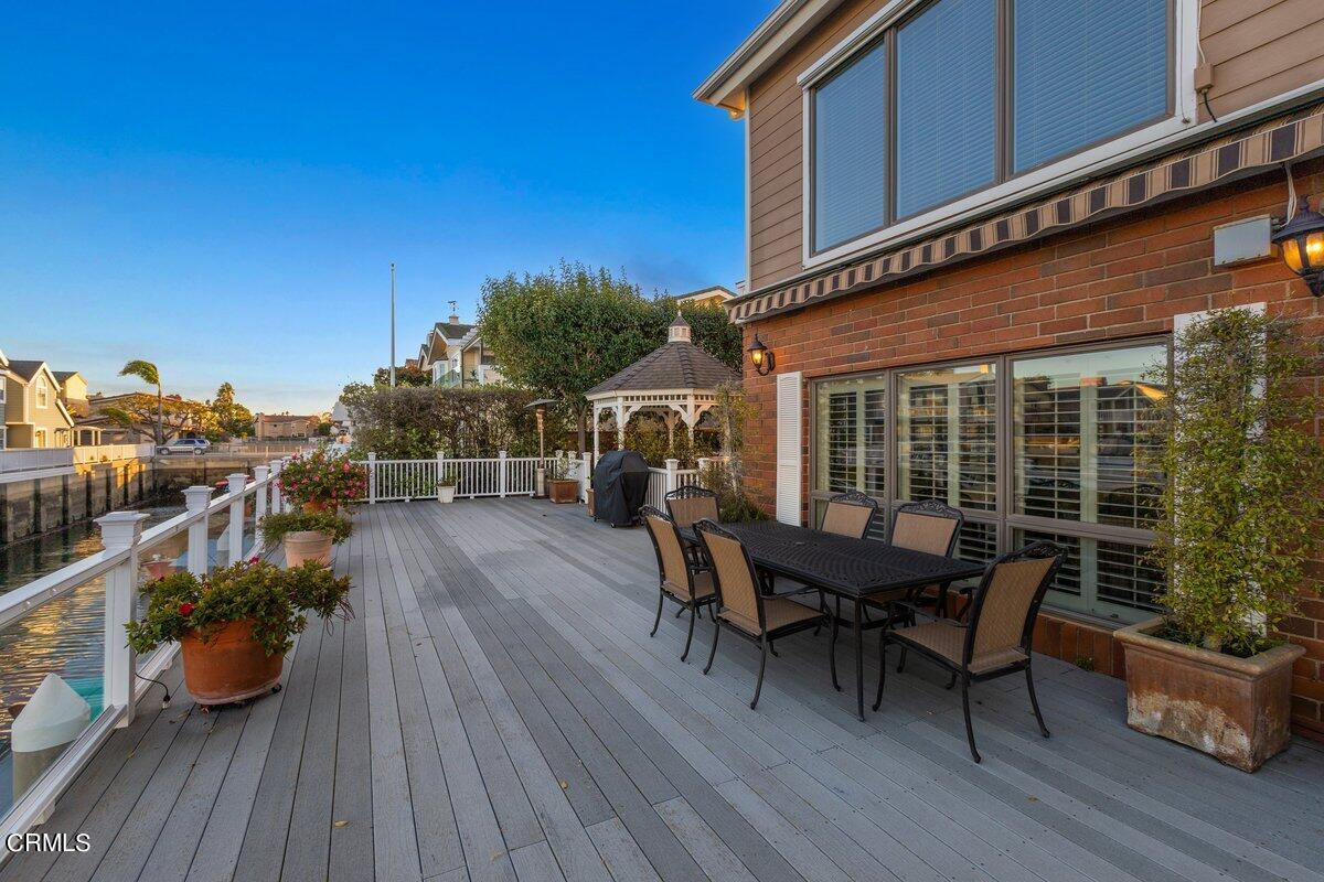 2300 Peninsula Road Oxnard, CA 93035 - Photo 40 of 54 a roof deck with table and chairs and wooden floor
