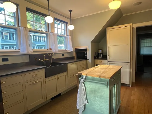 a kitchen with cabinets and wooden floor