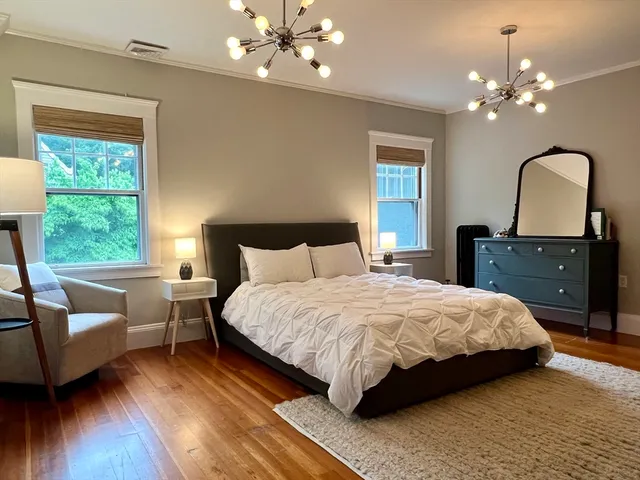 a bedroom with a bed lamp and a large window