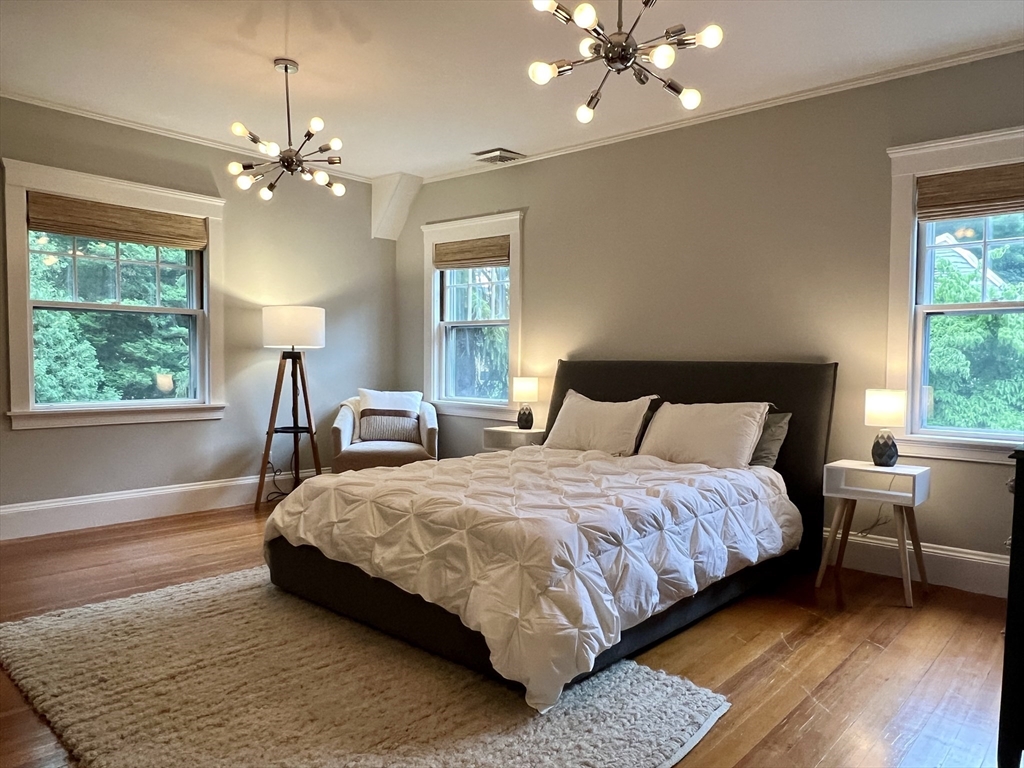 211 Forest Street Winchester, MA 01890 - Photo 25 of 41 a bedroom with a bed lamp and a large window