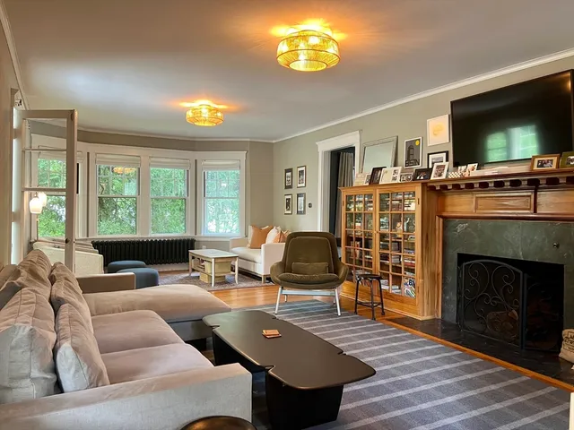 a living room with furniture a flat screen tv and a fireplace