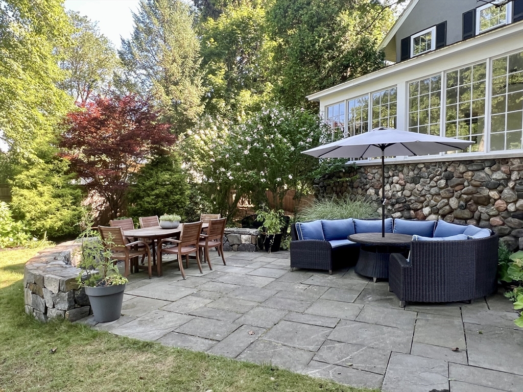 211 Forest Street Winchester, MA 01890 - Photo 34 of 41 a view of a patio with couches and chairs under an umbrella